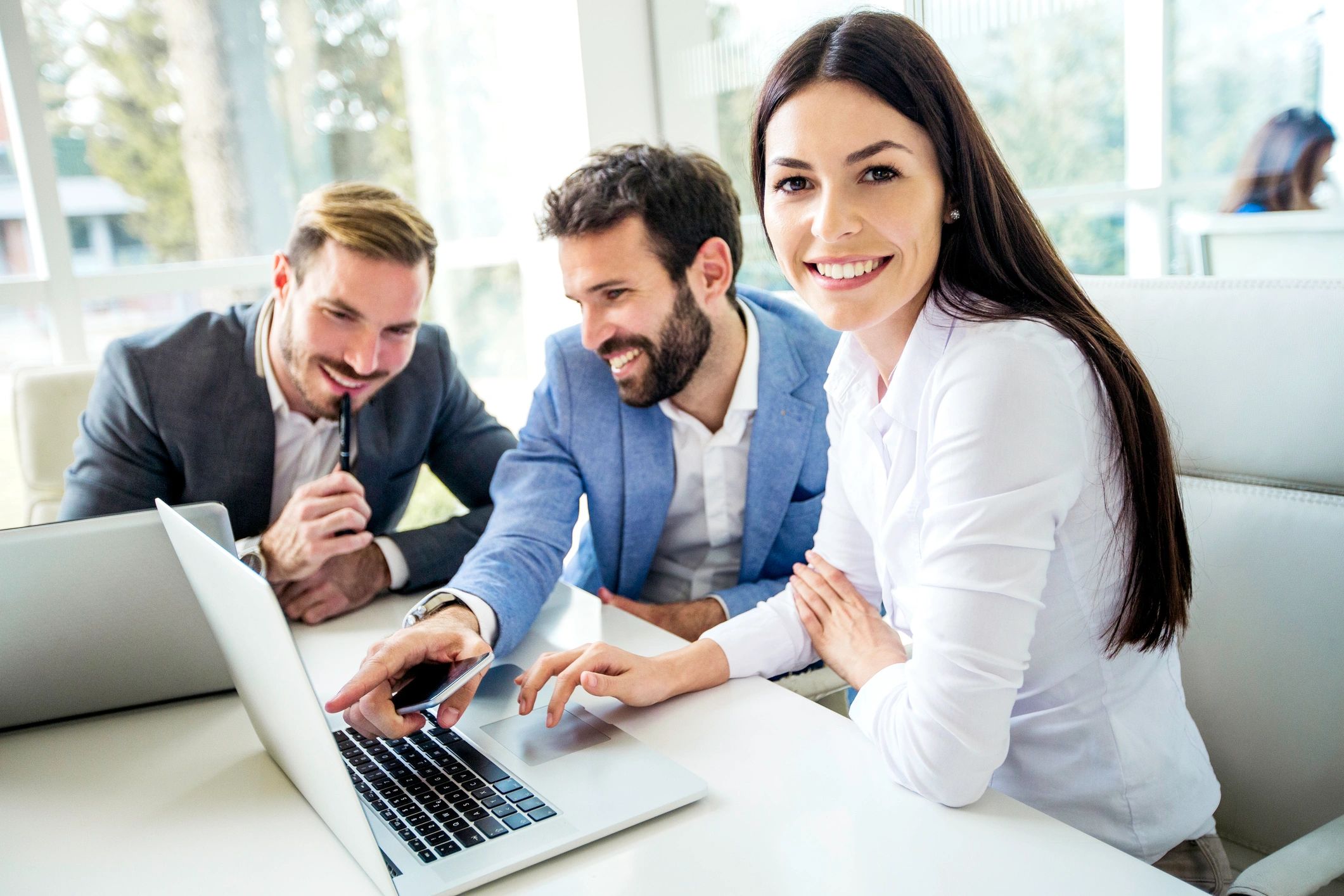 IT support team collaborating at a laptop in an office